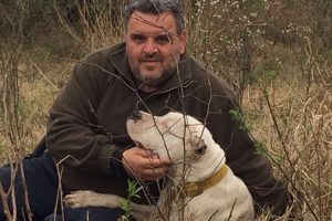 man with his white dogo argentino